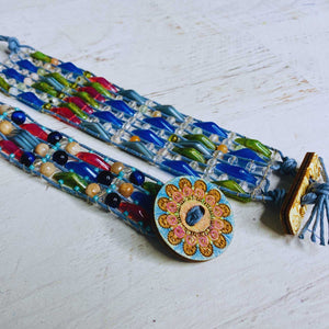 Jewel Loom Jewel Box Colorful beaded bracelets with a decorative clasp on a light wooden surface