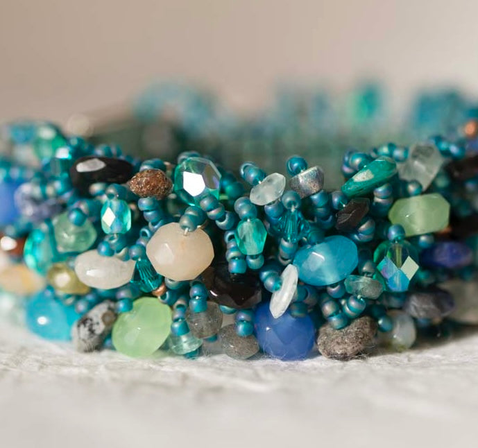 Teal seed bead bracelet with clustered aqua and blue gemstone and crystal beads, made on the Beadalon Jewel Loom by Julianna C. Avelar