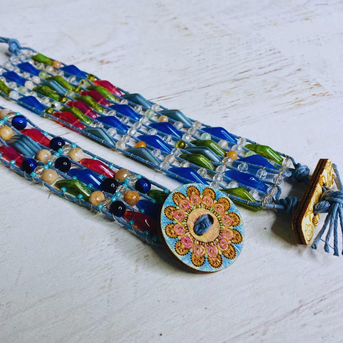 Jewel Loom Jewel Box Colorful beaded bracelets with a decorative clasp on a light wooden surface