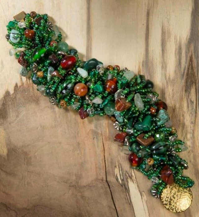 Wide green seed bead cuff with red jasper and green gemstone chips and a gold coin clasp, made on the Beadalon Jewel Loom by Julianna C. Avelar